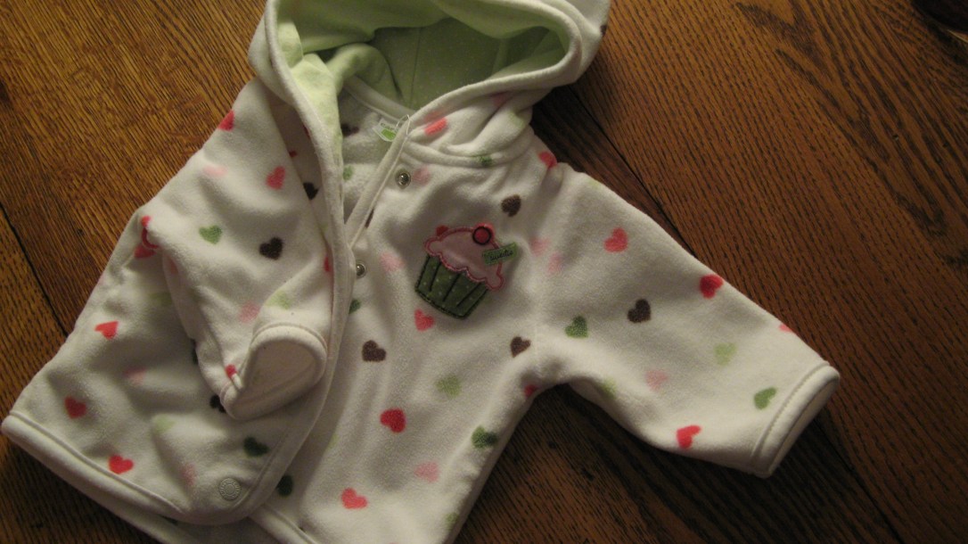 white fleece baby sweatshirt with hearts and a cupcake applique