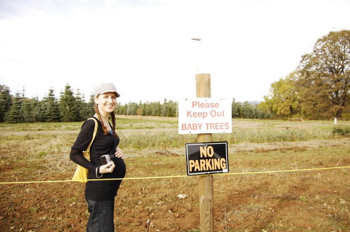 gina (oaxacaborn) at a christmas tree farm at apple hill in camino california next to a 'keep out: baby trees' sign