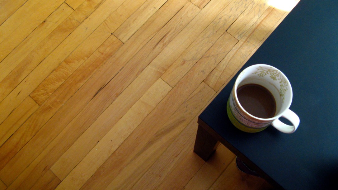 coffee mug on a black Ikea coffee table in a hardwood floor living room