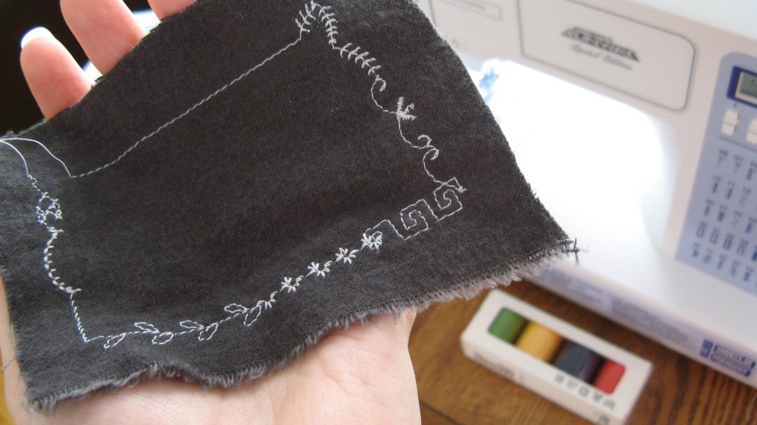 sample decorative stitches in white thread on grey flannel