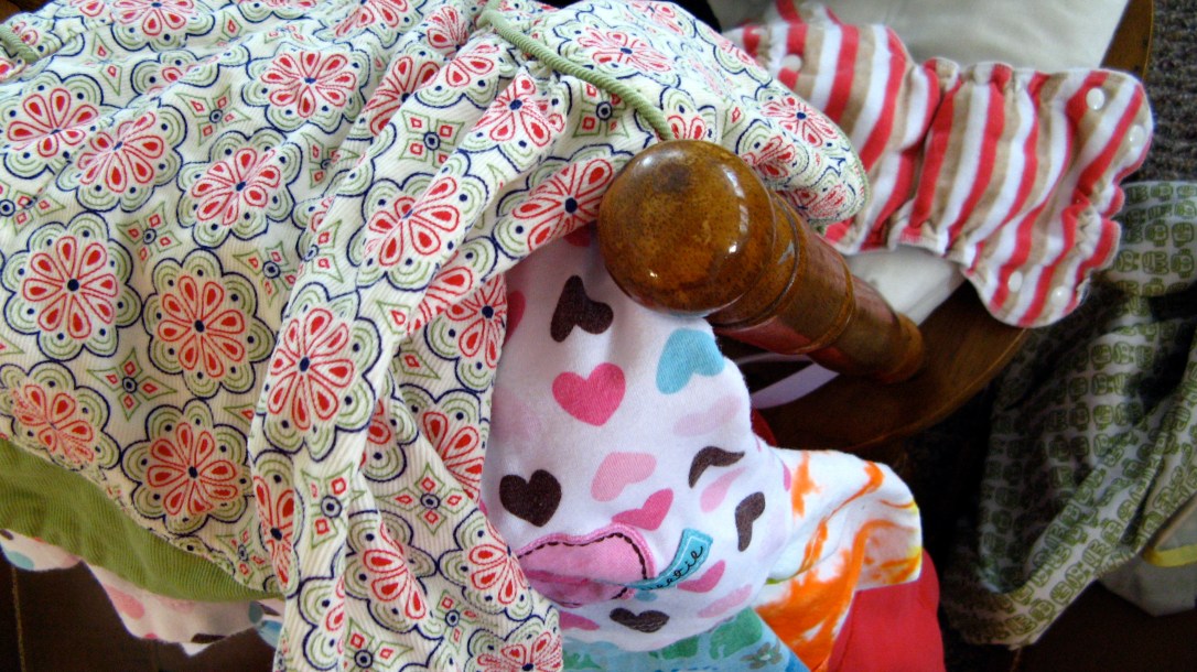 clean laundry hanging over back of wooden chair