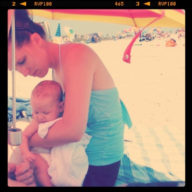 Gina and Aveline under umbrella at Cocoa Beach - baby's first trip to the Atlantic Ocean