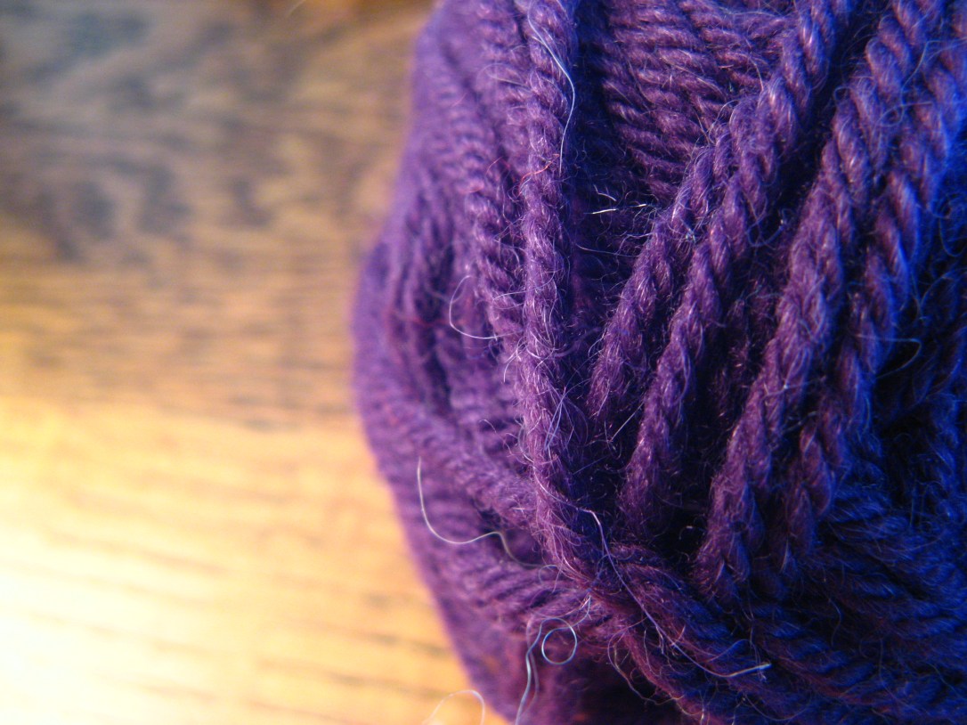 purple yarn with wood grain table in background