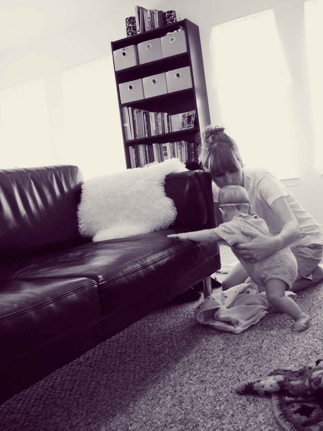 Oaxacaborn - Mother with her arm around baby daughter learning to stand up on furniture