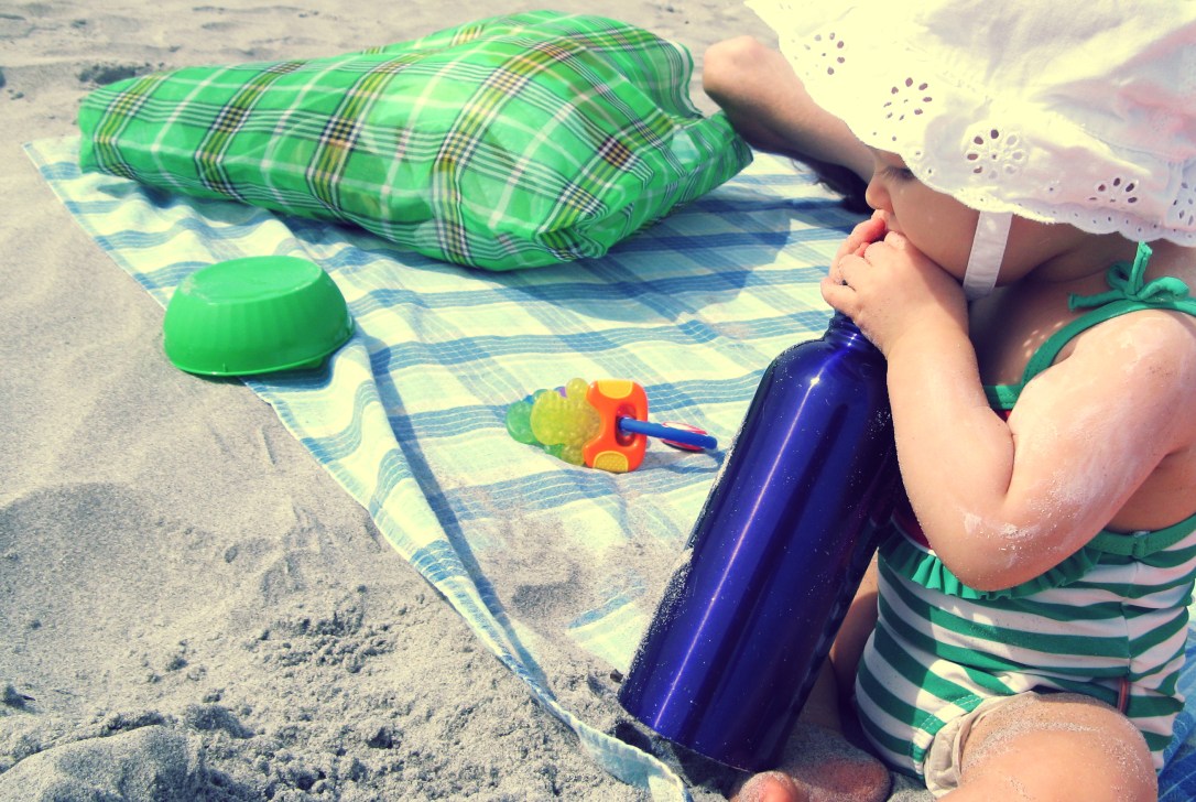 Aveline in sun hat with plaid bolsa and stainless steel water bottle