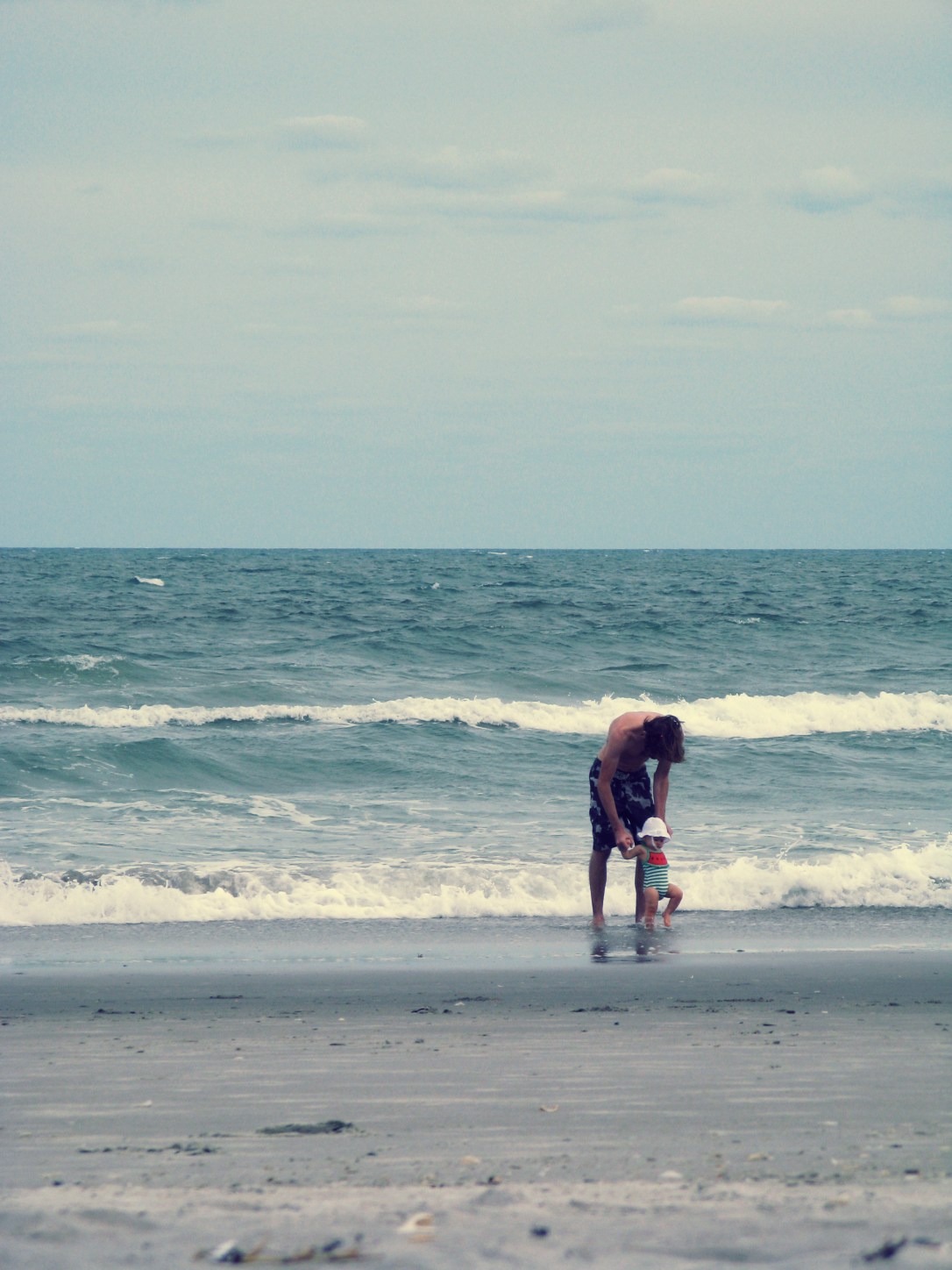 Josiah and baby Aveline in stormy Atlantic Ocean on Cocoa Beach 