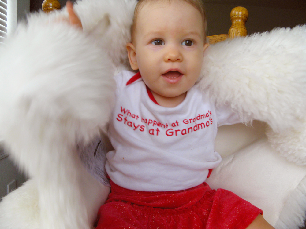 Aveline holding up sheepskin, on chair