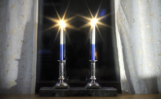 Two candles for itsenäisyyspäivä on window sill - photo via Studio55.fi