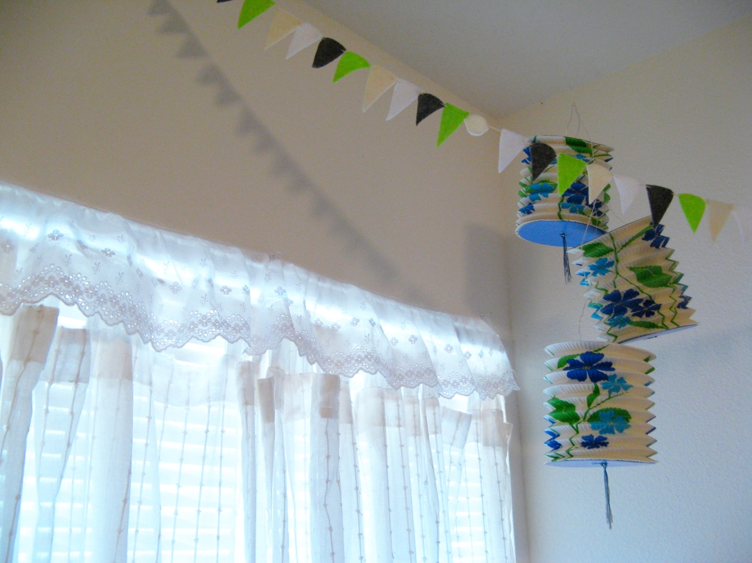 Curtains, bunting, and lanterns in the corner of Aveline's room
