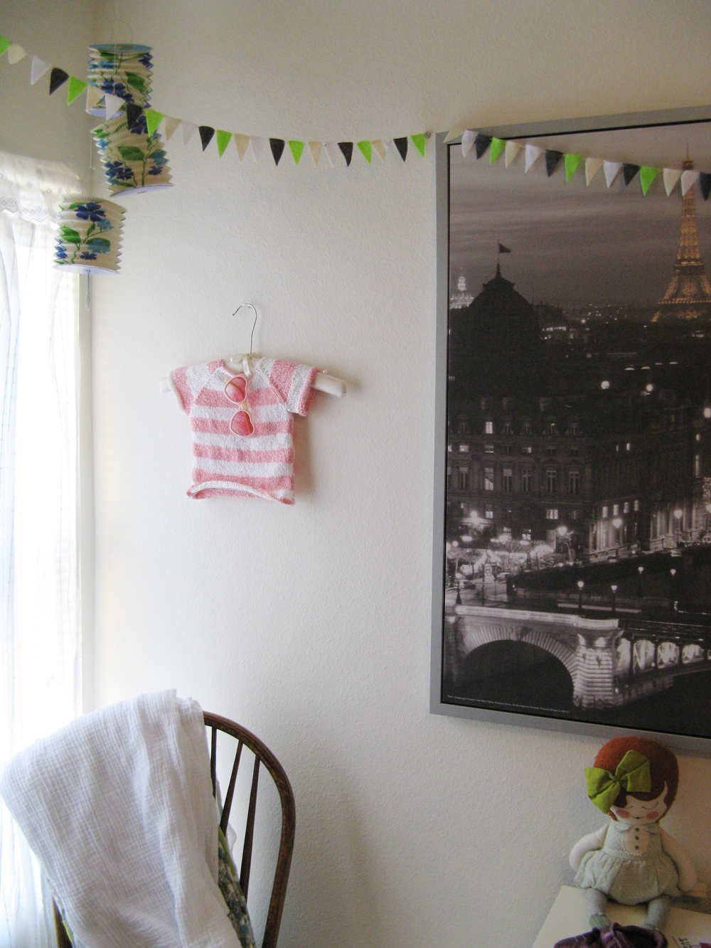 Aveline's room tour via Oaxacaborn - Huge framed canvas of Paris, bunting, paper lanterns, blankets over chair and doll
