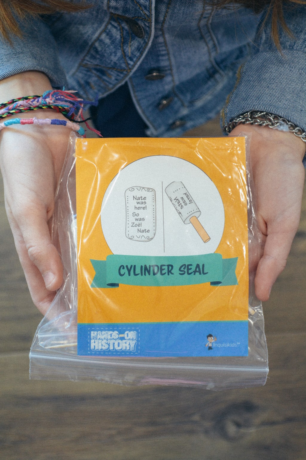 A homeschool student shows the activity kit to create a cylinder seal, from Sonlight's Hands-on History project box 