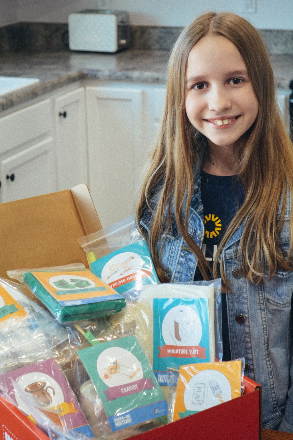A homeschool student unboxes a Sonlight Hands-on History box 