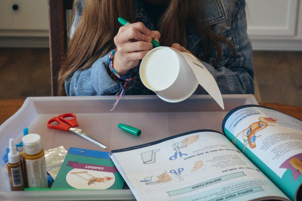 A student consults a Sonlight Curriculum instruction book while working on a hands-on history project