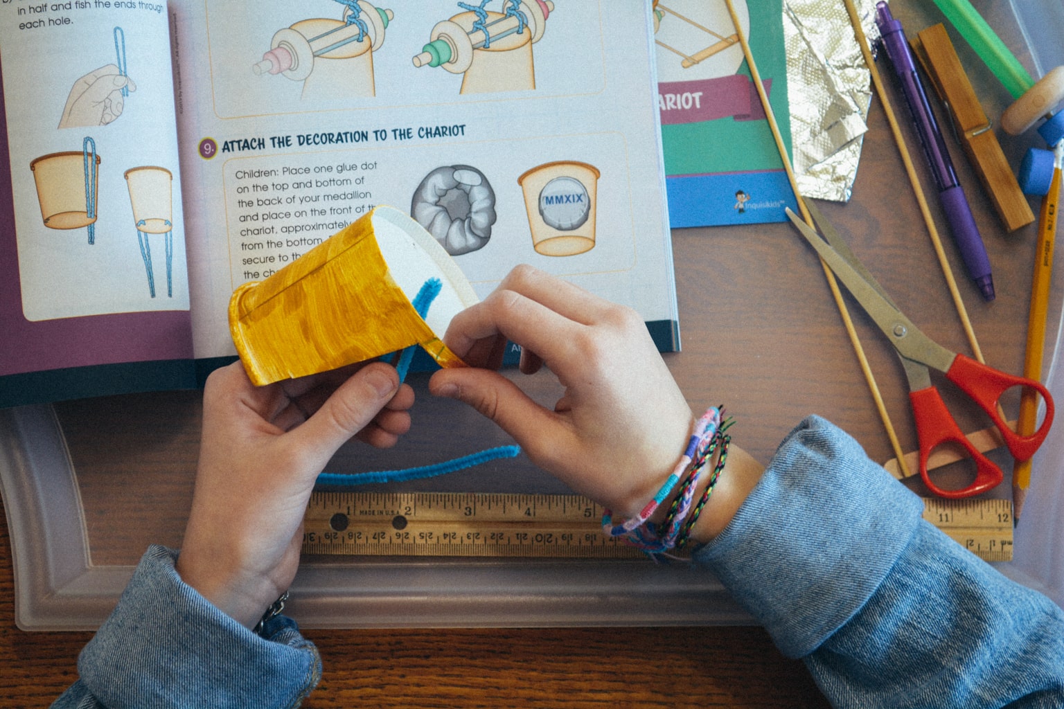 An overhead view of a student actively working on the Roman chariot project from Sonlight Curriculum's Hands-on History project box