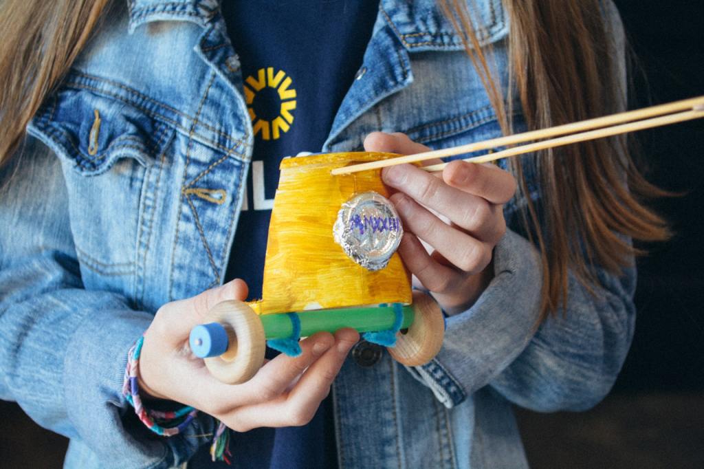 A homeschool student holds a miniature model of a Roman Chariot from Sonlight's Hands-on History box