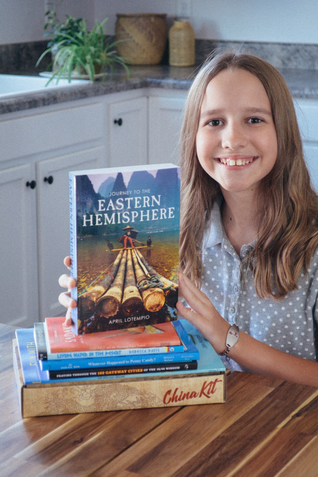 Homeschool student holds up Journey to the Eastern Hemisphere by Sonlight Curriculum