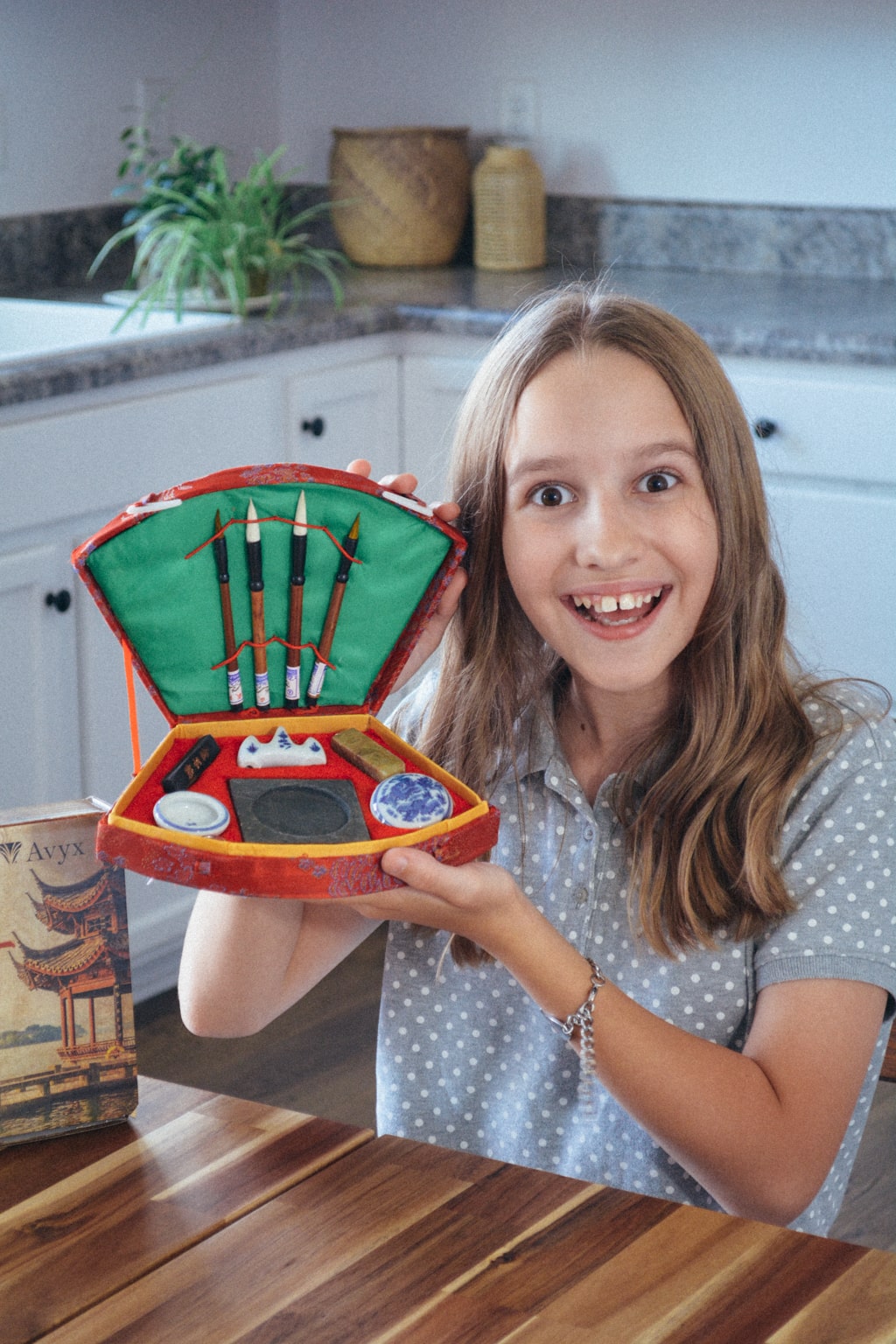 Homeschool student shows the inside of the Chinese calligraphy kit included in Sonlight Curriculum's Eastern Hemipshere studies