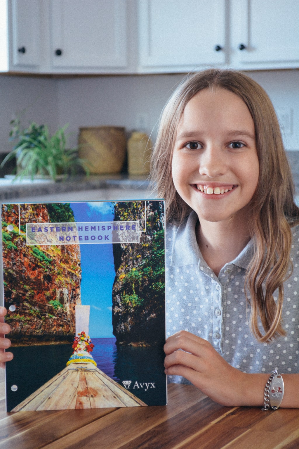 A homeschool student shows the cover of Sonlight's Eastern Hemisphere notebook