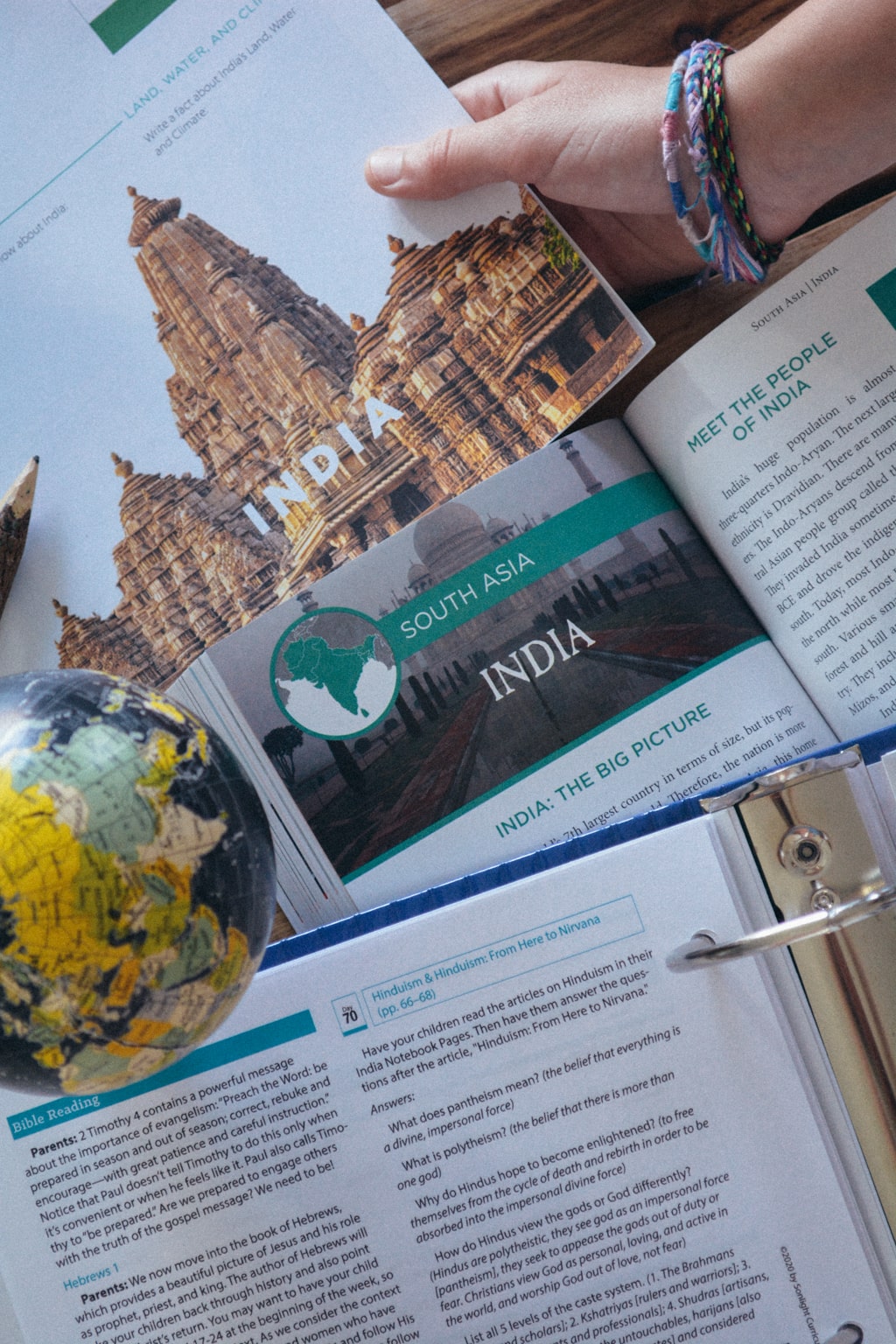 Sonlight's Eastern Hemisphere Instructor's Guide, open to a page on India, and the Journey to the Eastern Hemisphere textbook and Eastern Hemisphere notebook both open to sections on India, while a globe nearby shows India.